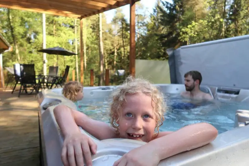 family enjoying a hot tub at Darwin Forest lodge