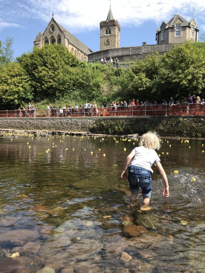 duck race, kids helping ducks move along the river