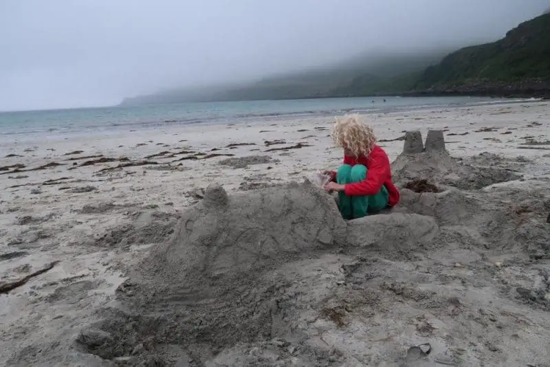 sand sculture of train with child sitting in it