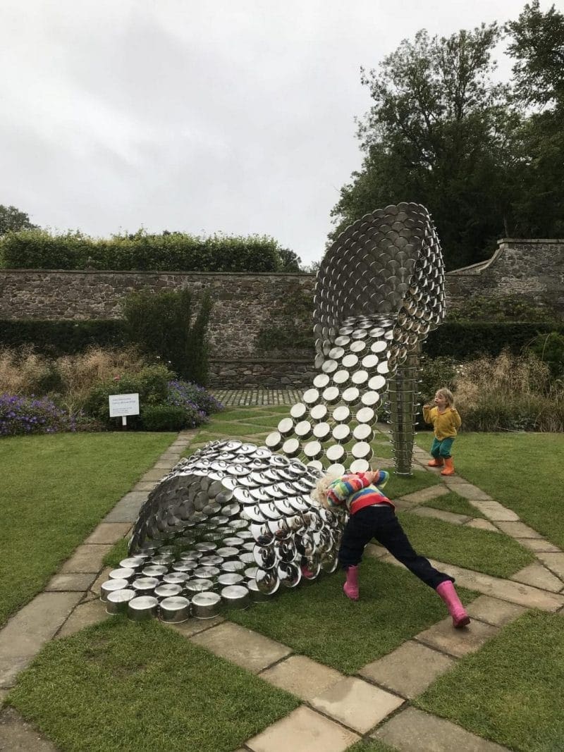 sculoture of shoe made from pots and pan lids