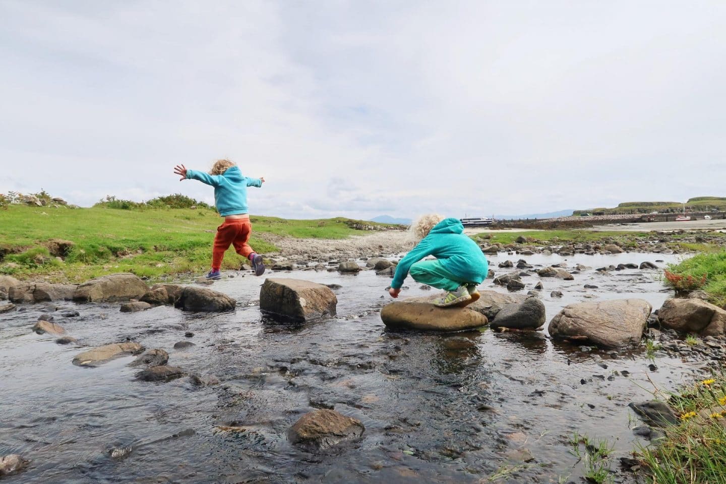 isle of eigg kids jumping on stones