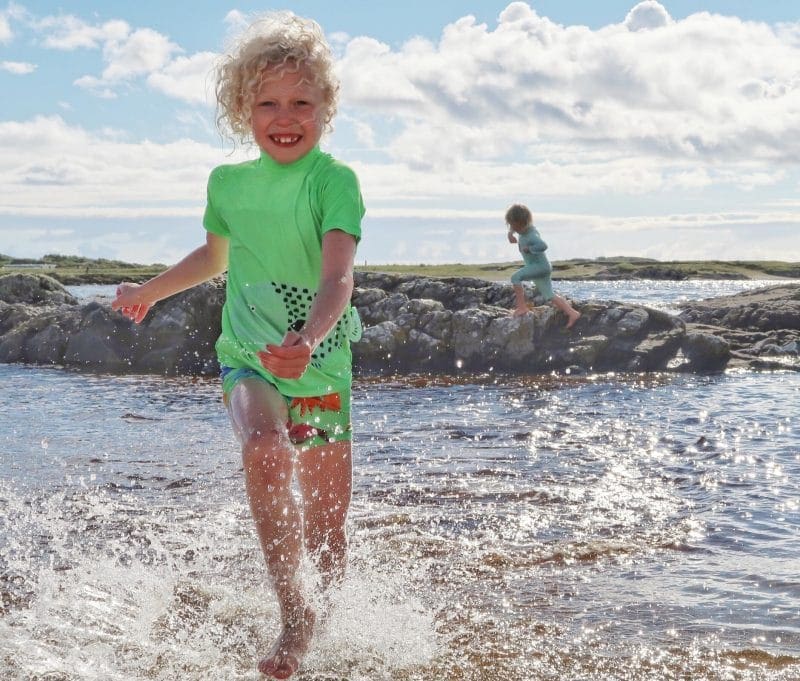 child splashing in Scottish sea