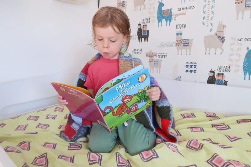 child reading book about chickenpox