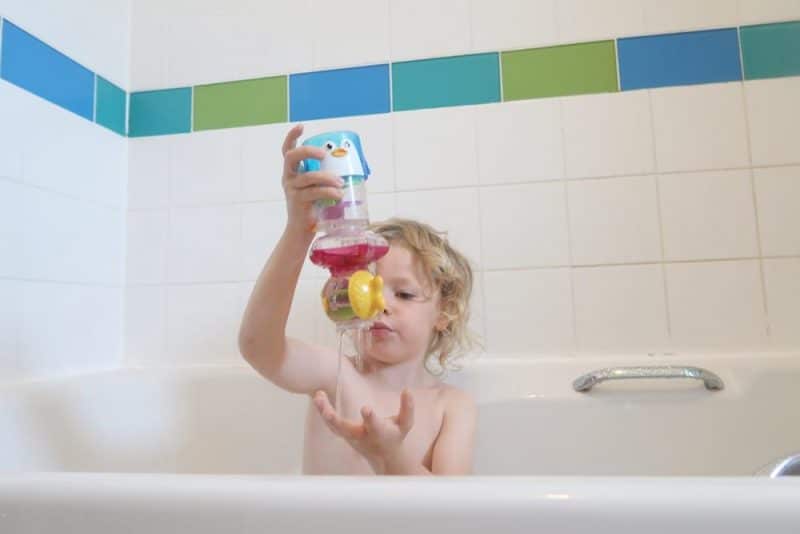 CHILD IN BATH WITH TOY