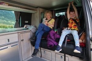 children in seats inside campervan