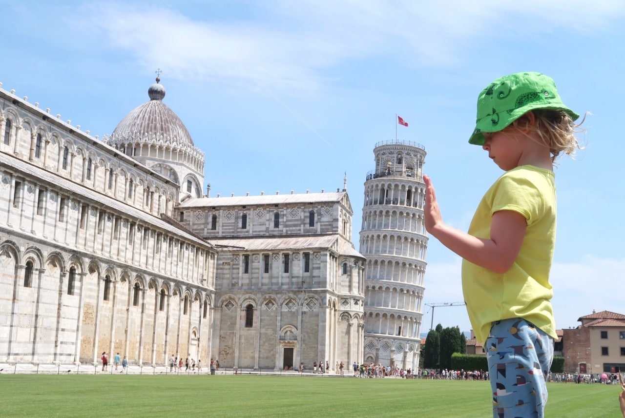 child holding up leaning tower of Pisa