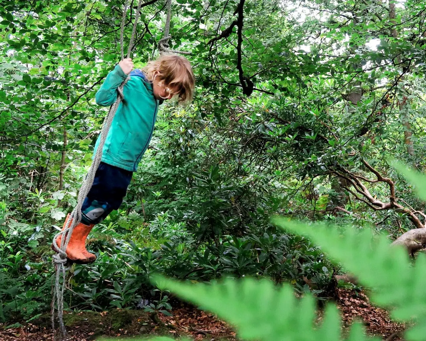 child swinging on a rope swing