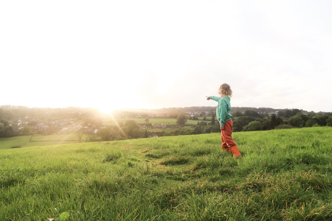 Child pointing at the village from hill