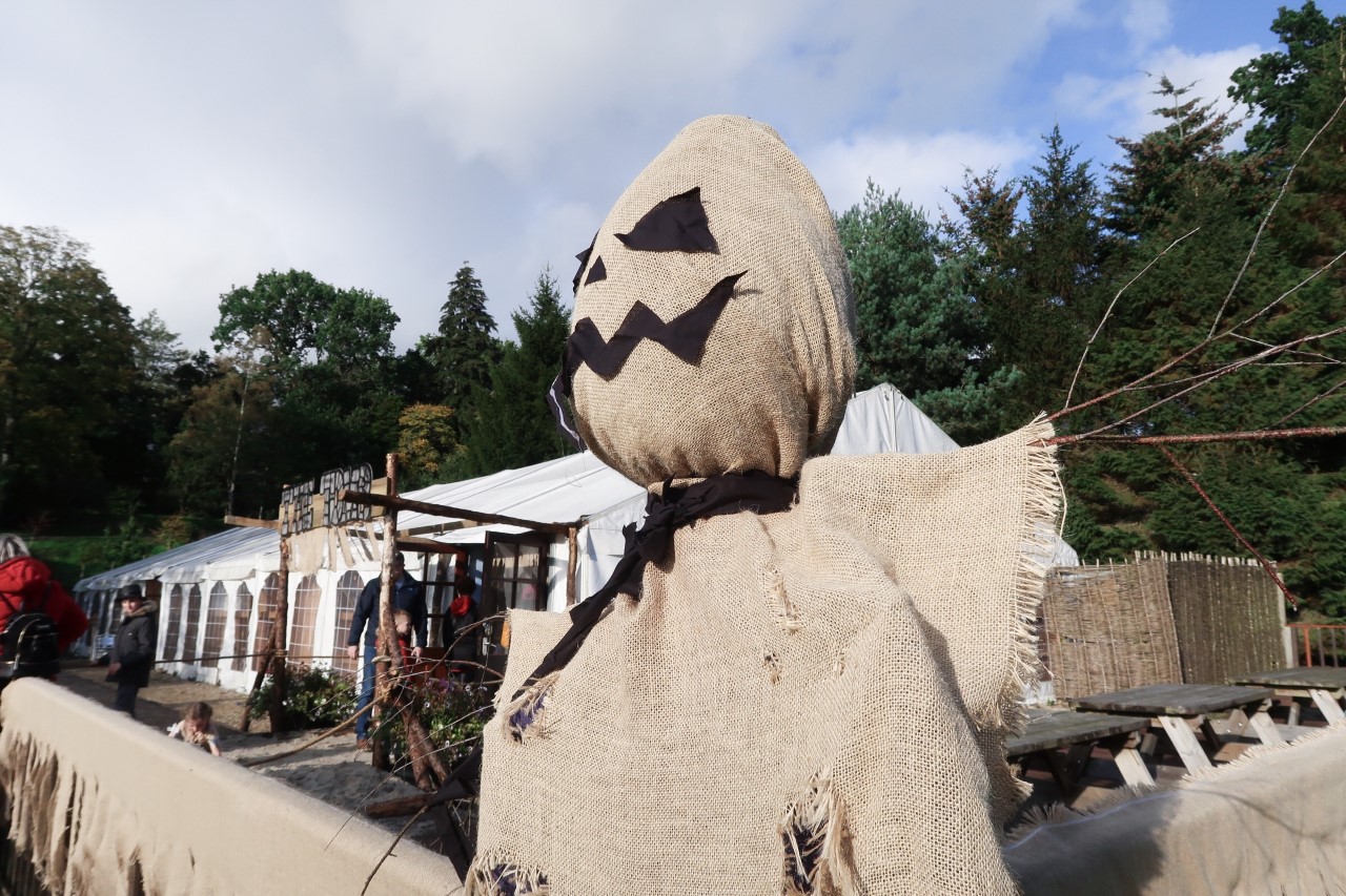 scary spooky house with scarecrow in front