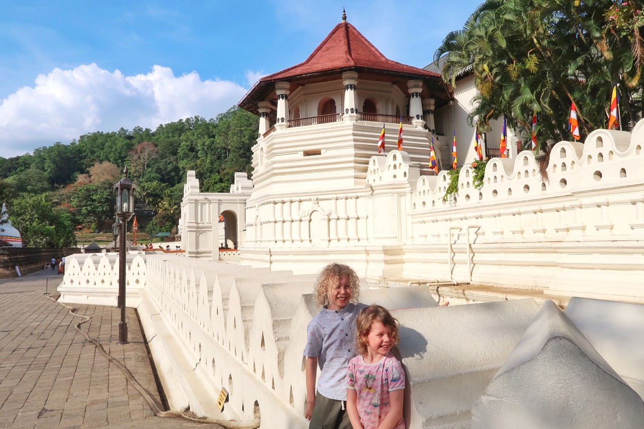 children standing in front of the temple of the tooth Sri Lanka