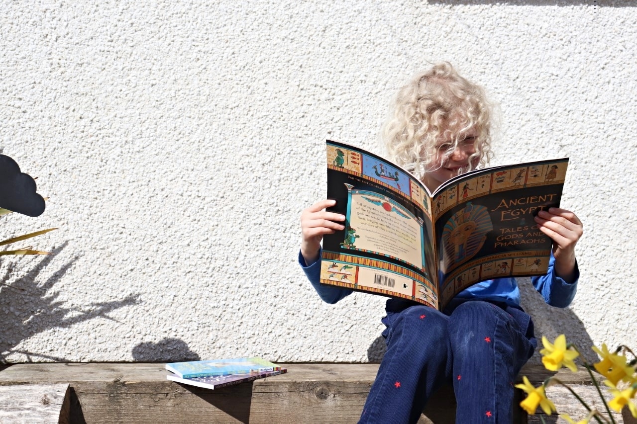 child reading an Egyptian book