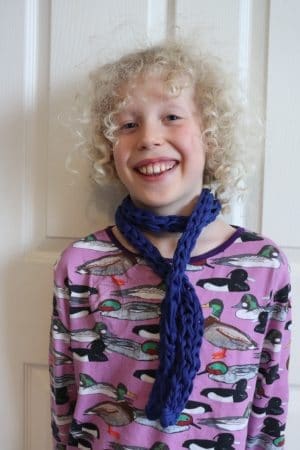 child wearing finger knit scarf