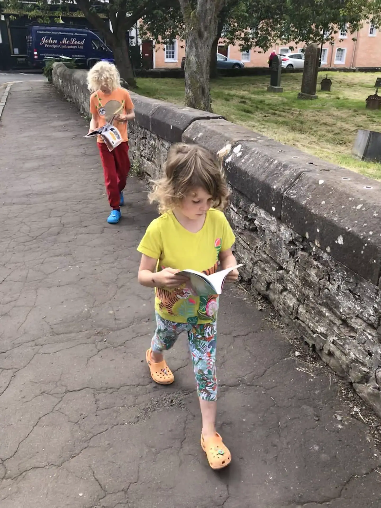 kids reading books whilst walking