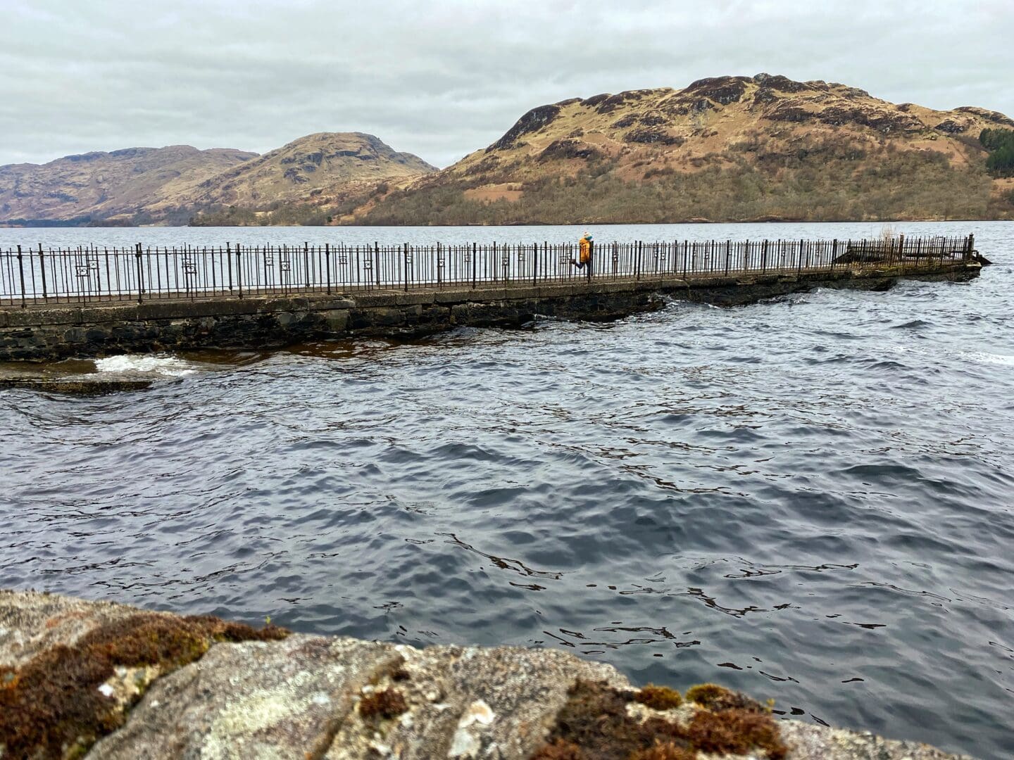 child running across the pier to the Royal Cottage on Loch Katrine