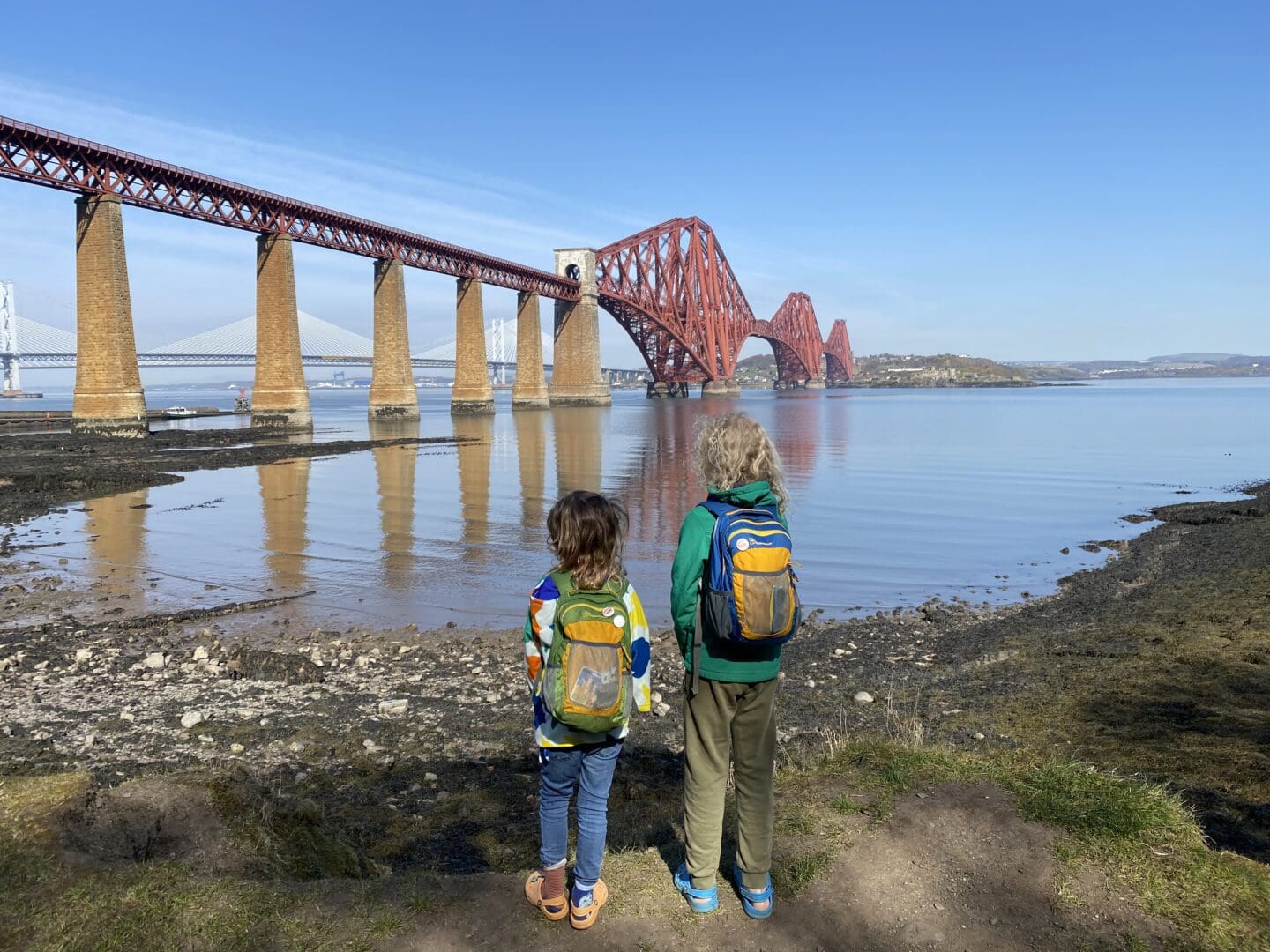children standing by the sea looking at the forth rail bridge