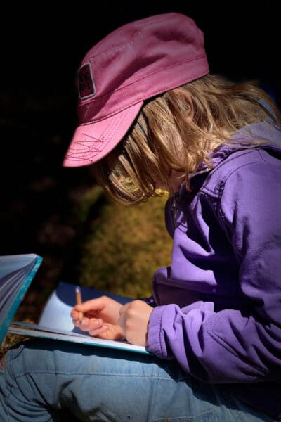 child drawing outdoors