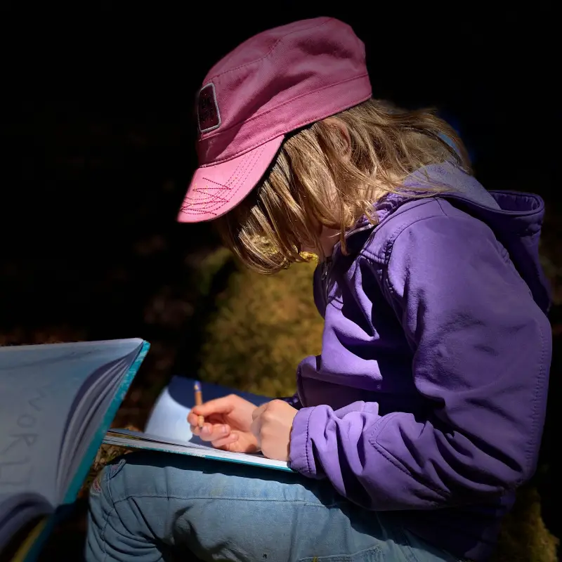 child drawing outdoors
