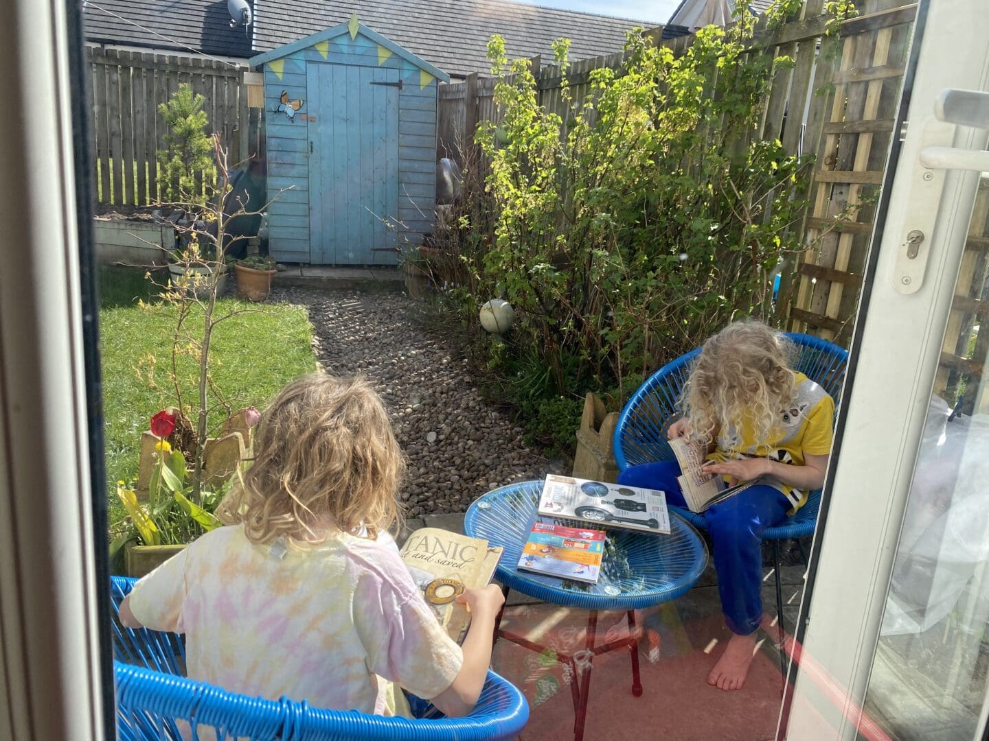 children reading library books about the Titanic in the garden