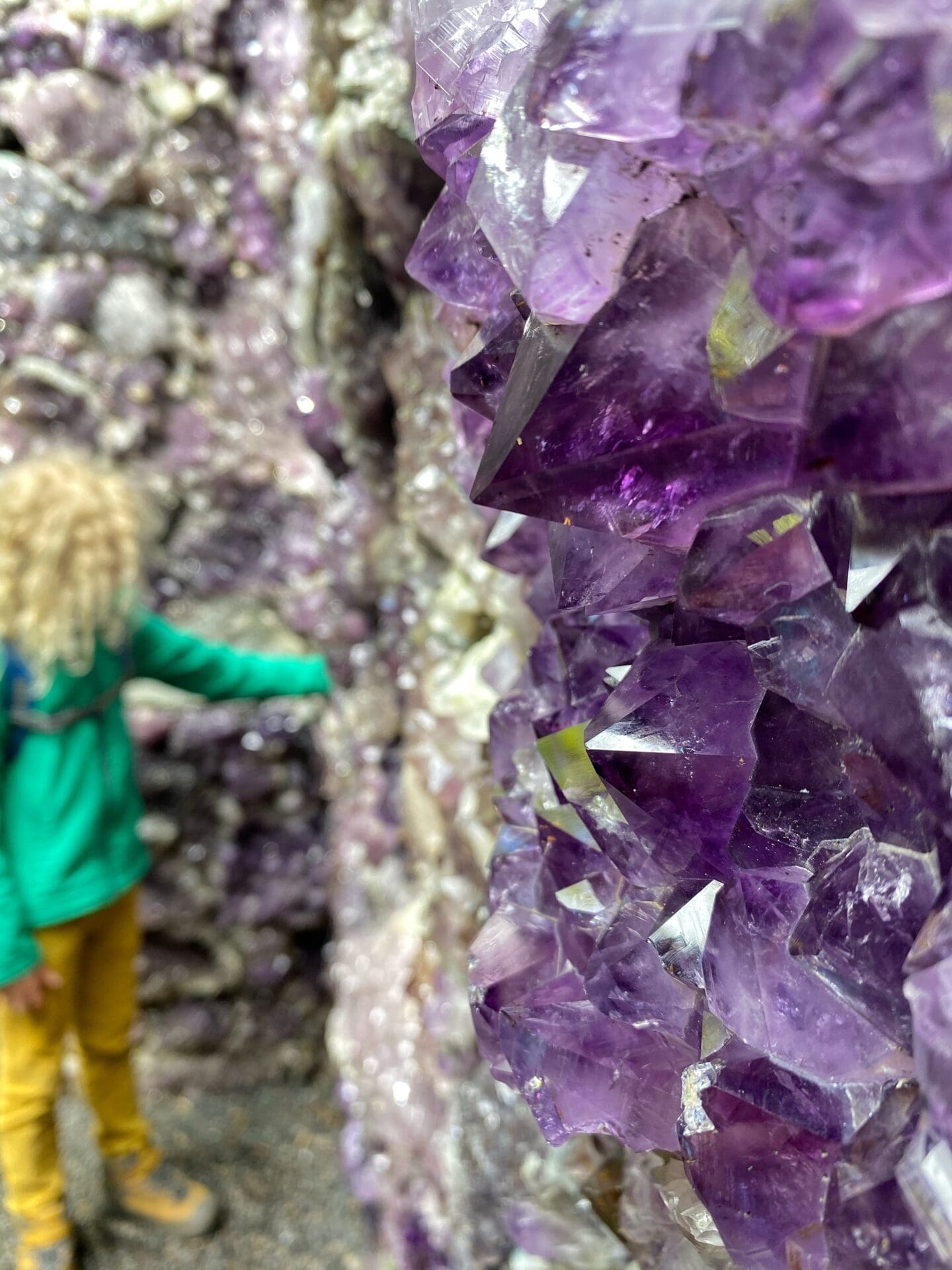 child touching amethysts in a 'cave' at Jupiter artland