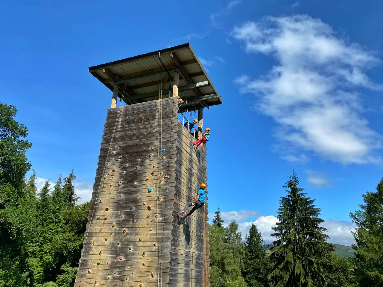 child and adult abseiling down a wooden tower in Perthshire