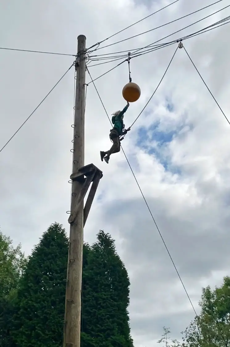 child jumping off a pole to hit a pole