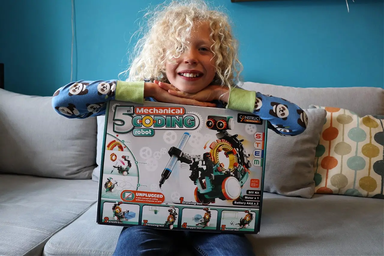 child posing with 3 in 1 robot mechanical coding stem toy