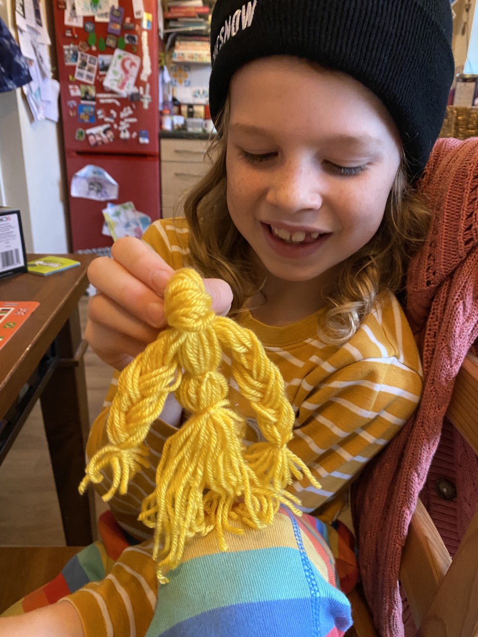 child with yarn doll
