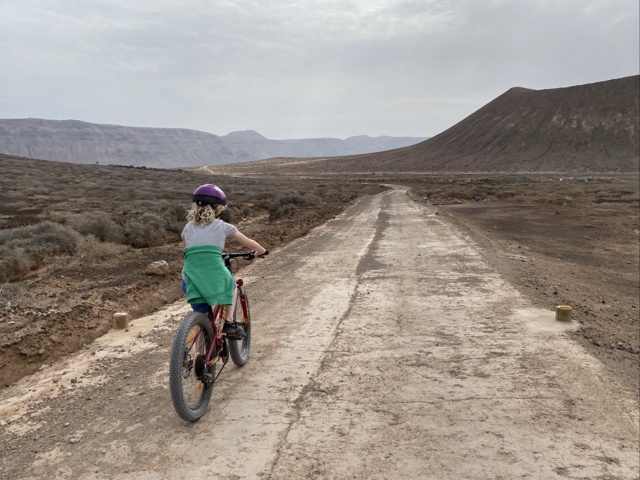 child cycling on volcanic island