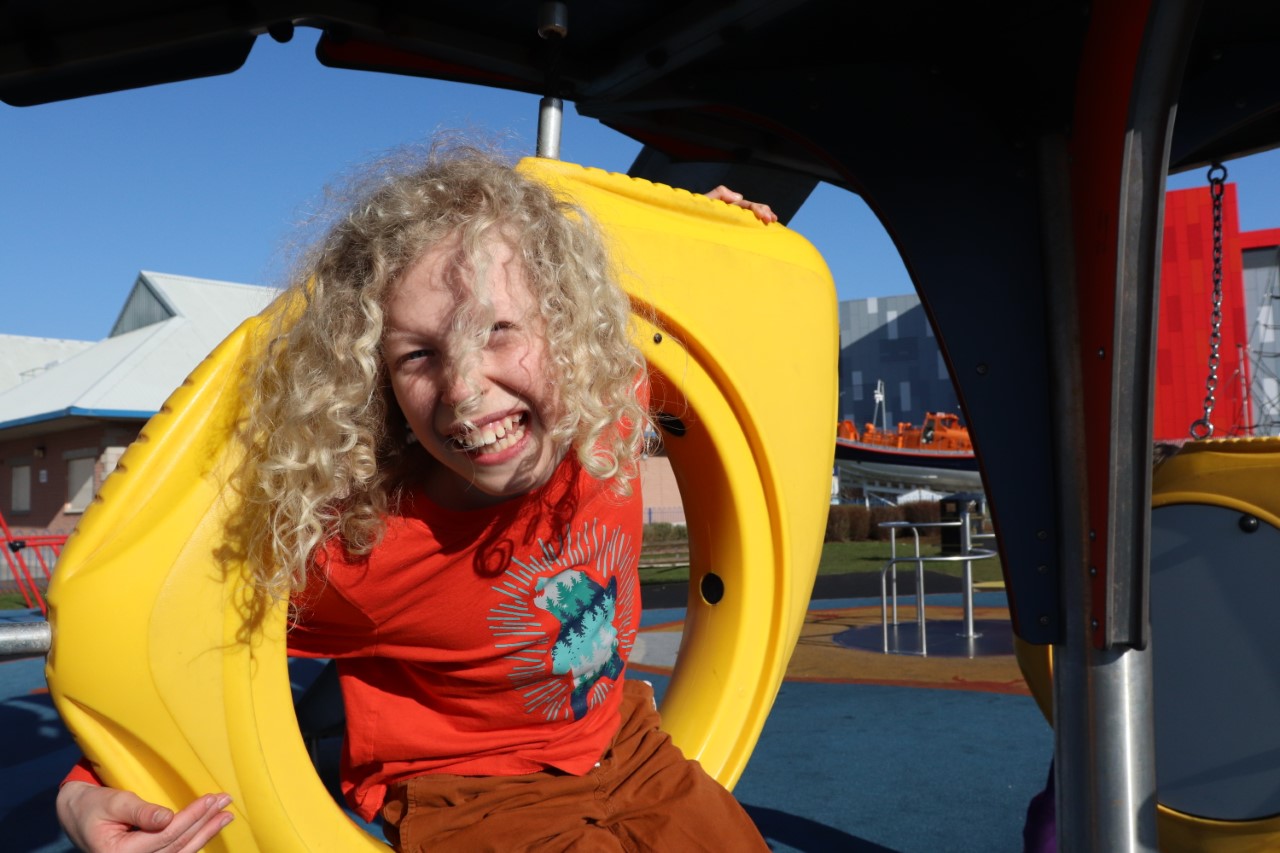 curly hair child playing at park