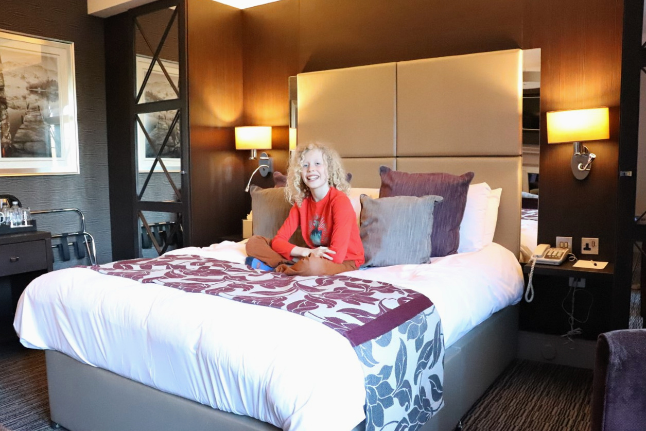 child sitting on hotel bed