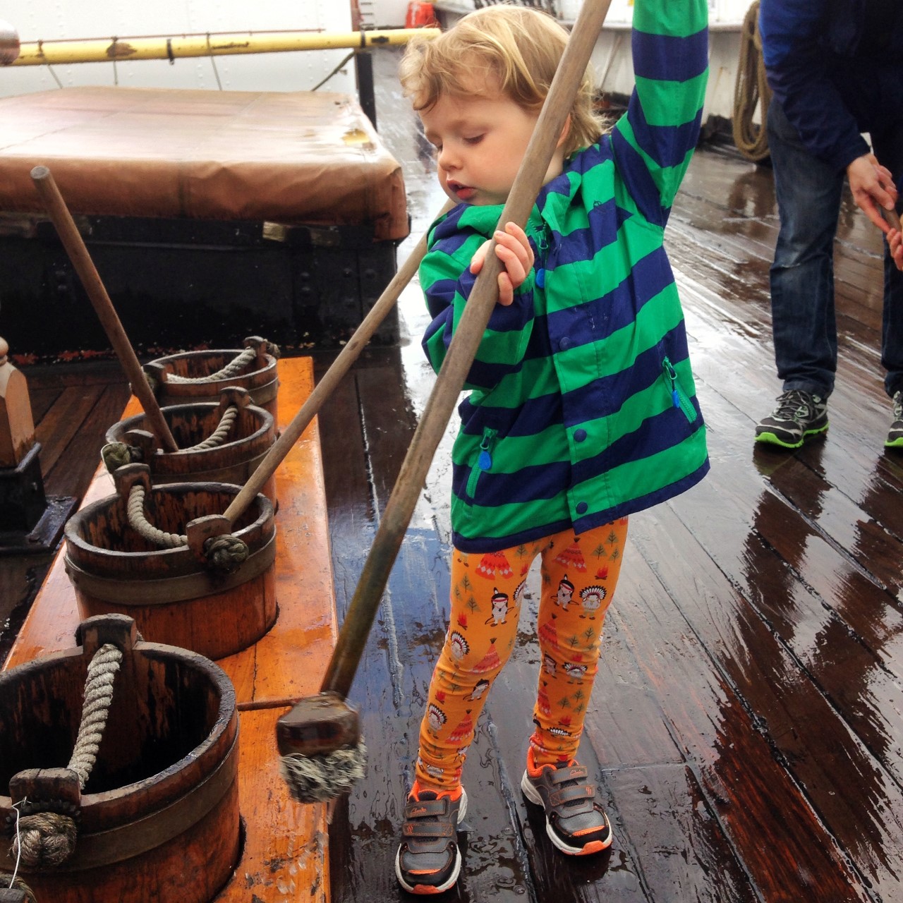 child swabbing deck of tall ship Glenlee