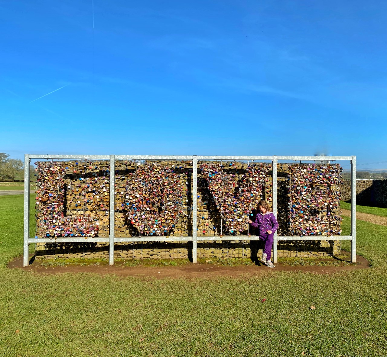 child in front of Gretna Green love padlock sign