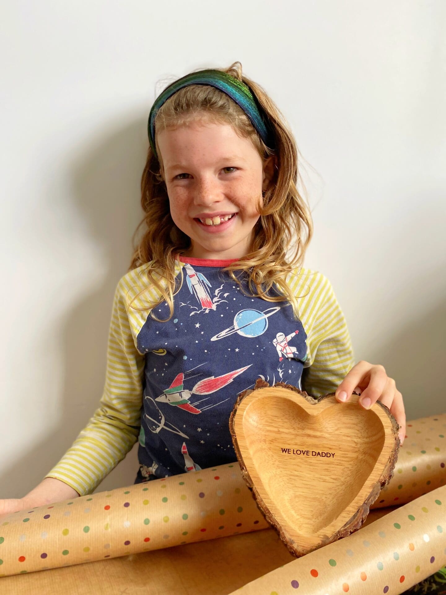 Child wrapping heart dish for Father’s Day