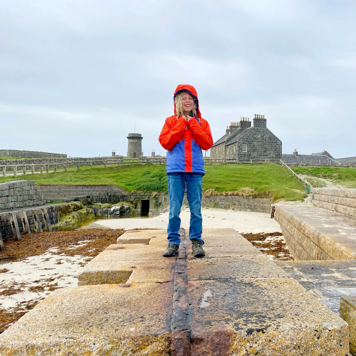 Child standing in front of old buildings on Tiree