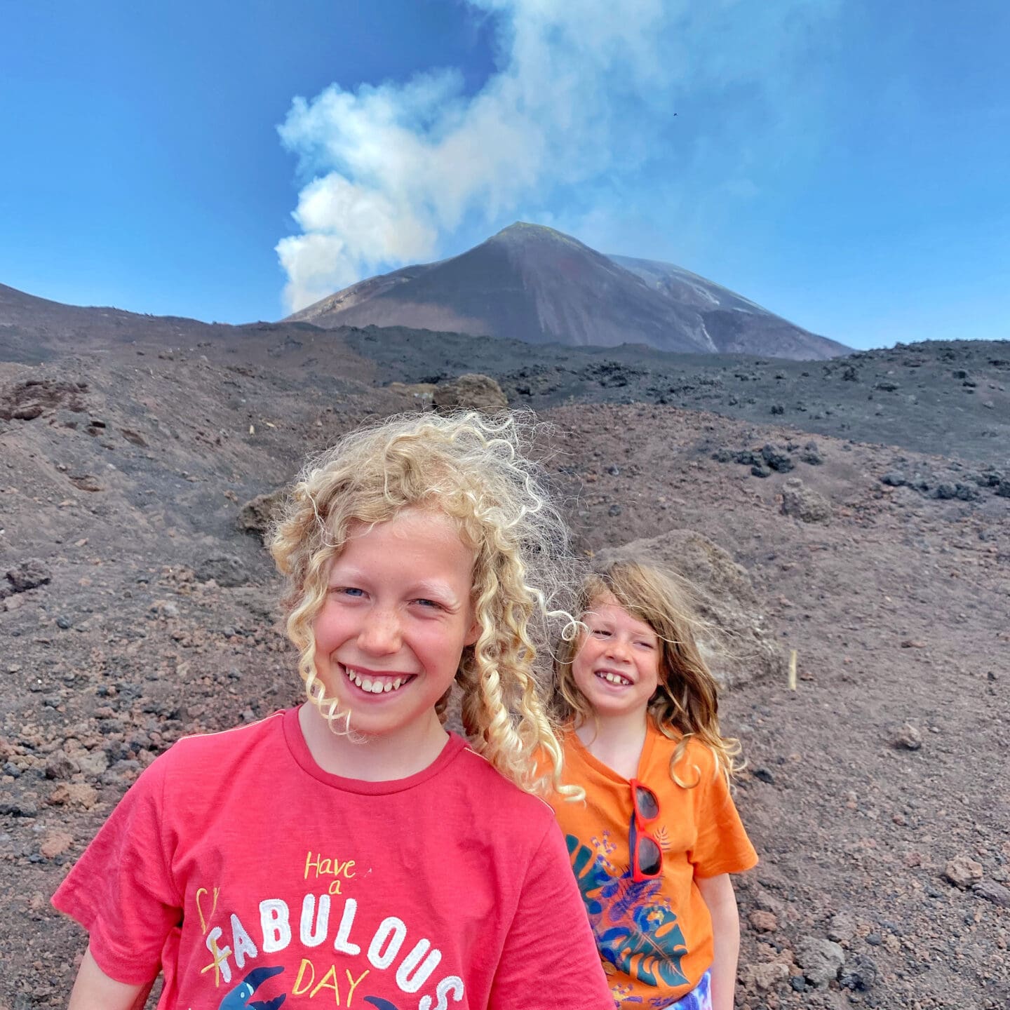 Kids wearing bright t-shirts beside mt Etna