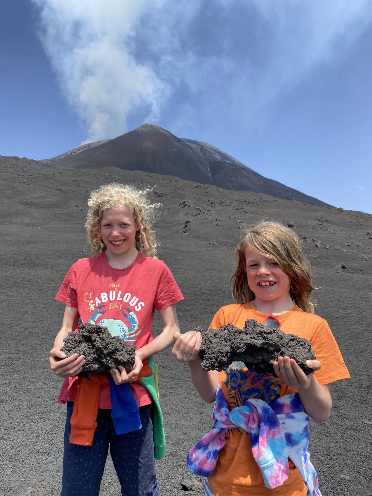 Children holding lava rock below Mt Etna