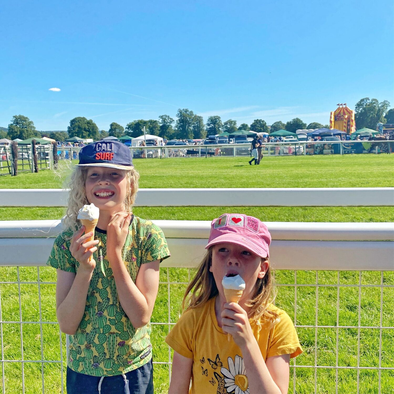 Children eating ice cream beside race course
