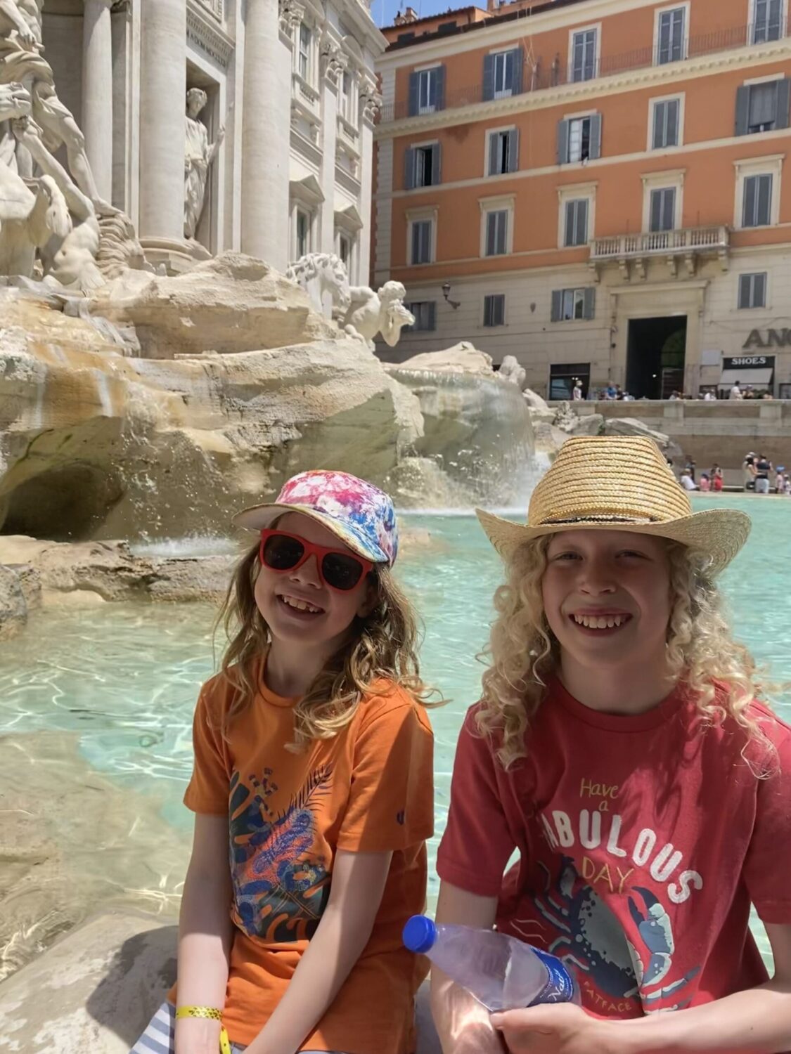 Children sitting on edge of the Trevi fountain