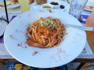 Pasta food dish with cutlery and drink