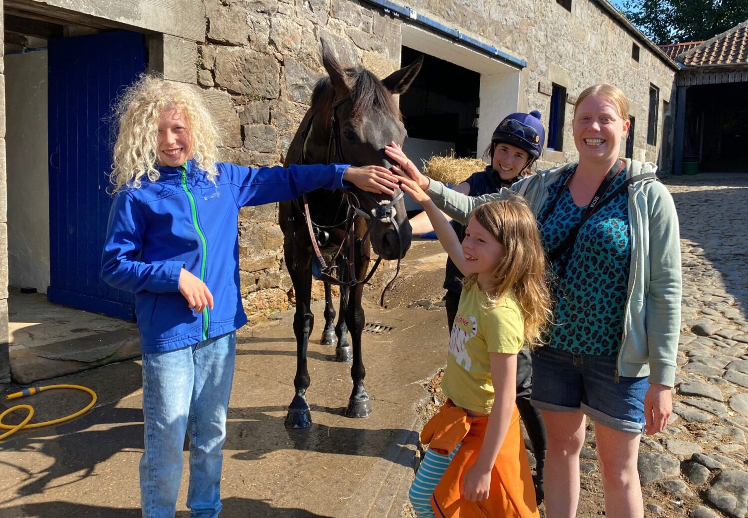 Family petting a racehorse