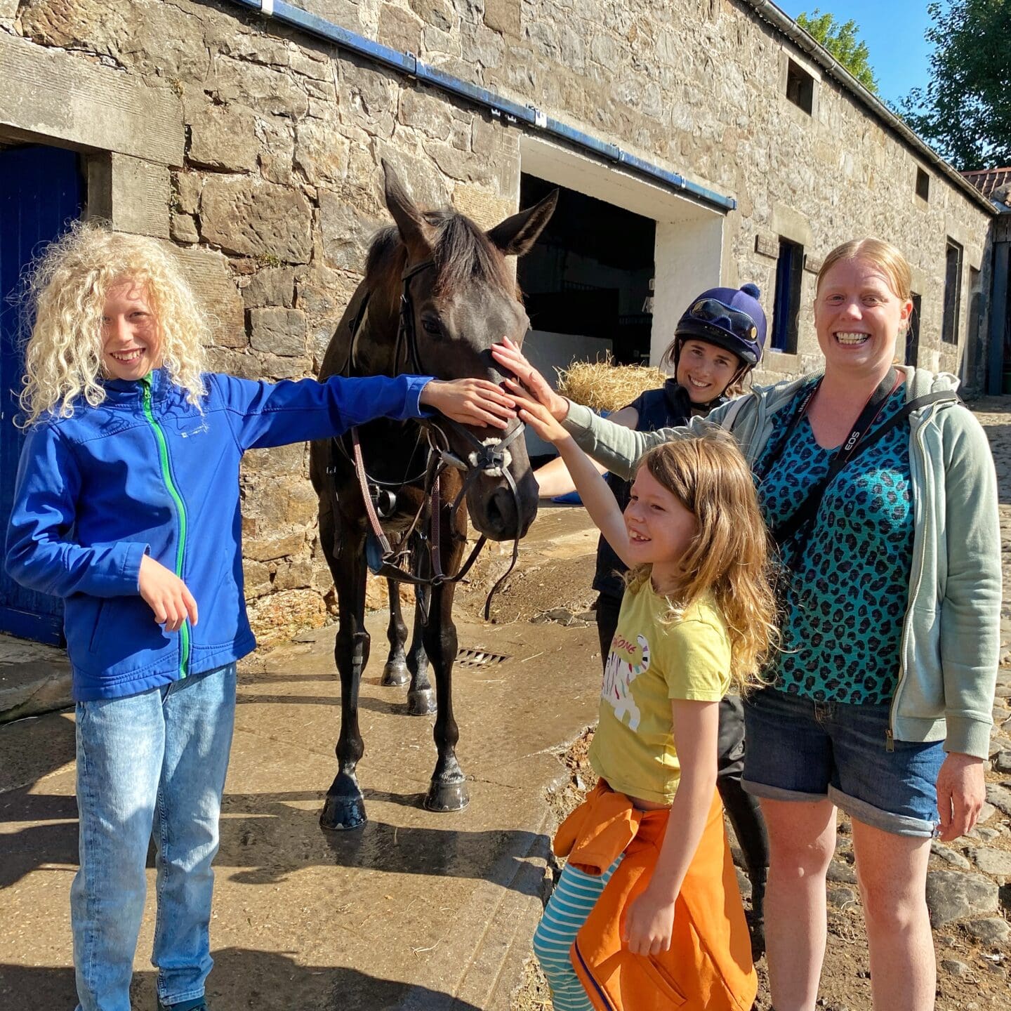 Family petting a racehorse