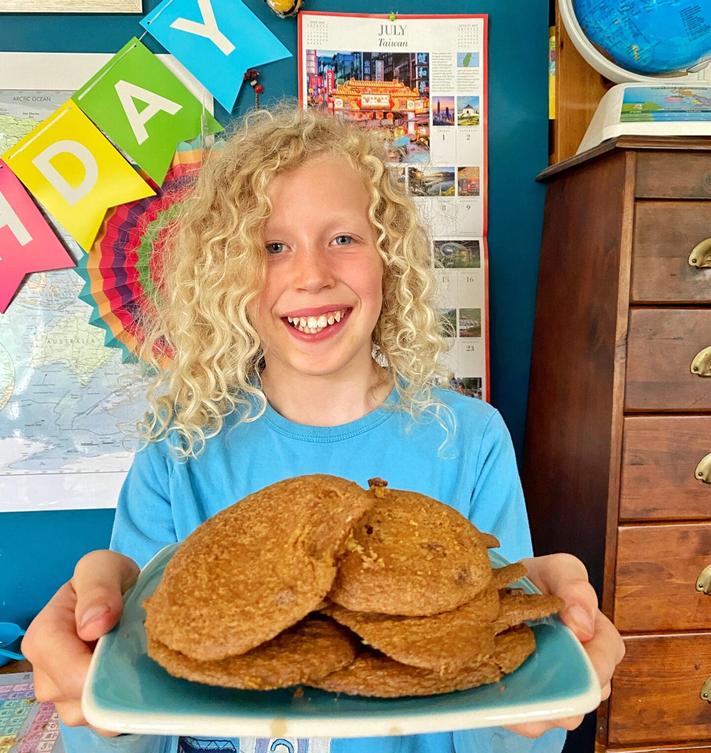 Child holding a plate of homemade cookies