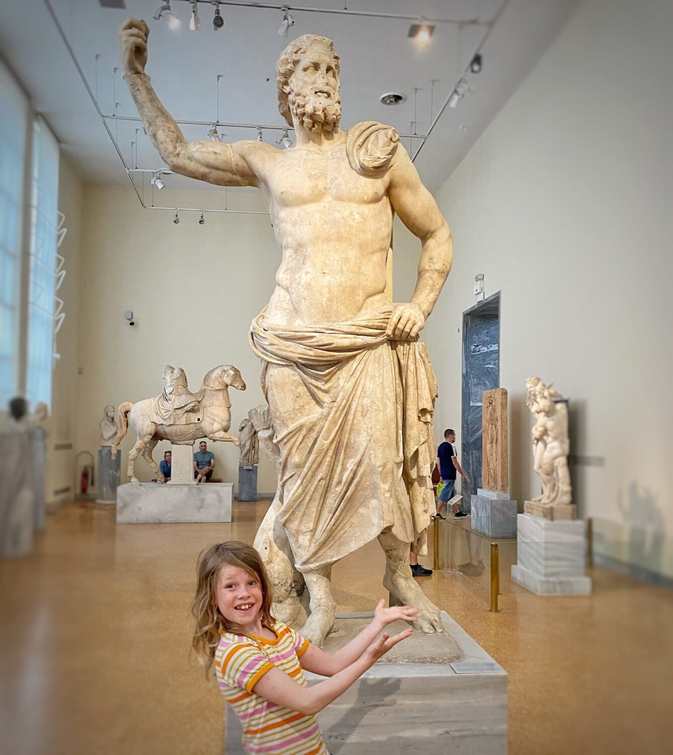 Child in front of Zeus or Poseidon statur Athens