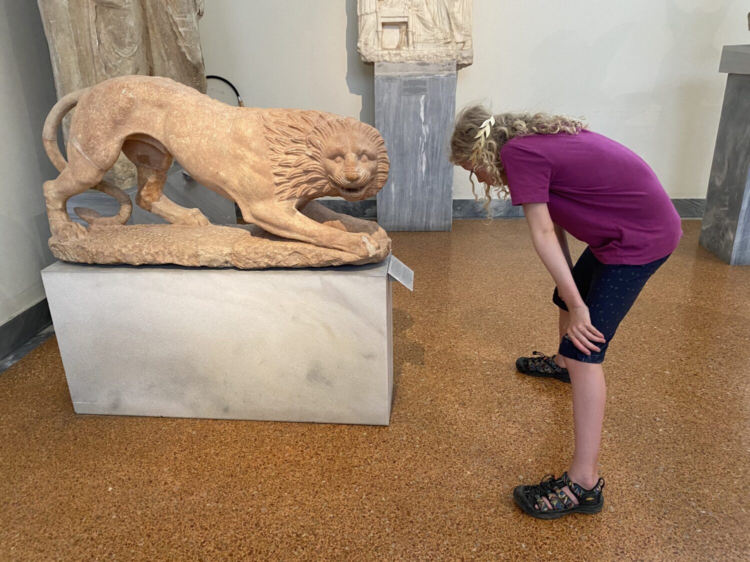 Child reading label on statue
