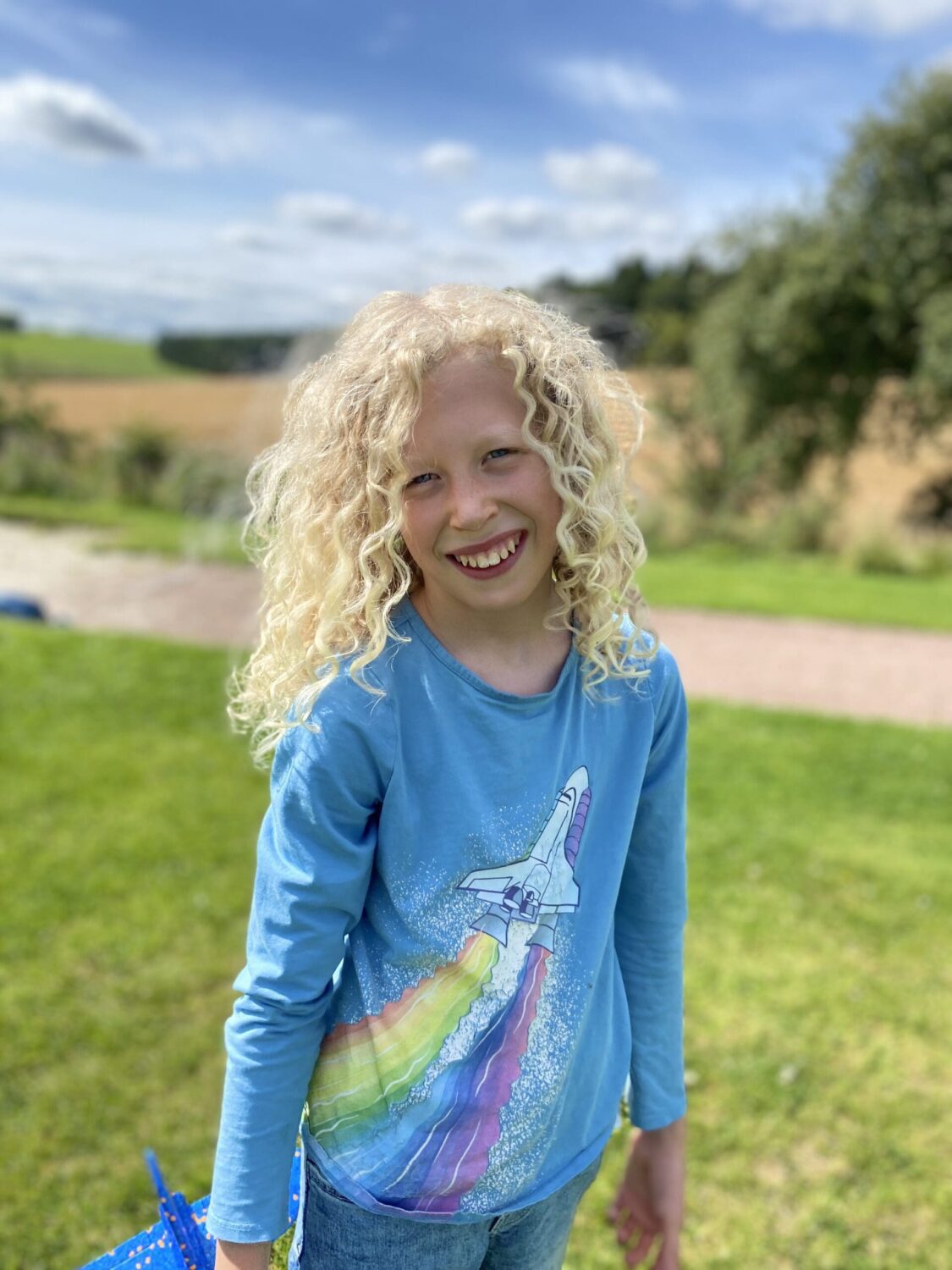 Child outside by green grass