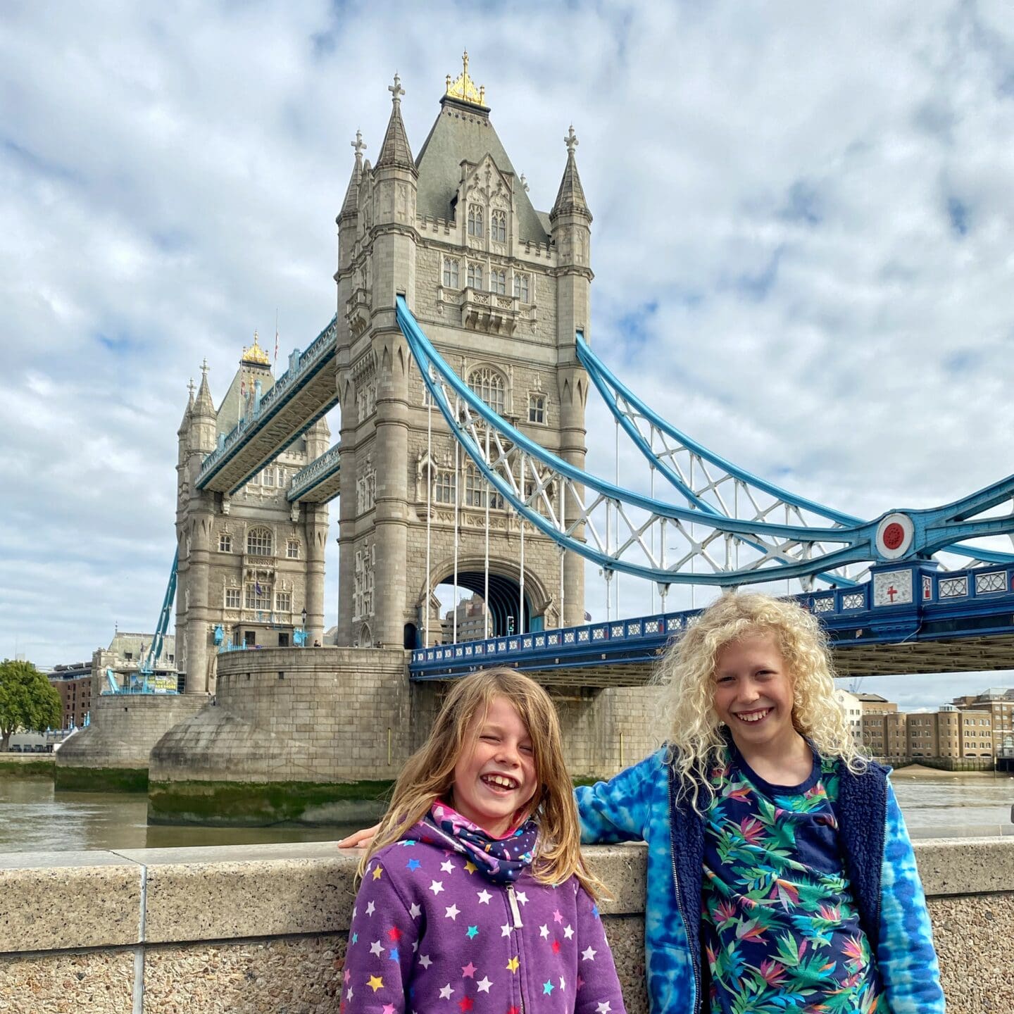 Tower bridge in London with kids smiling in front