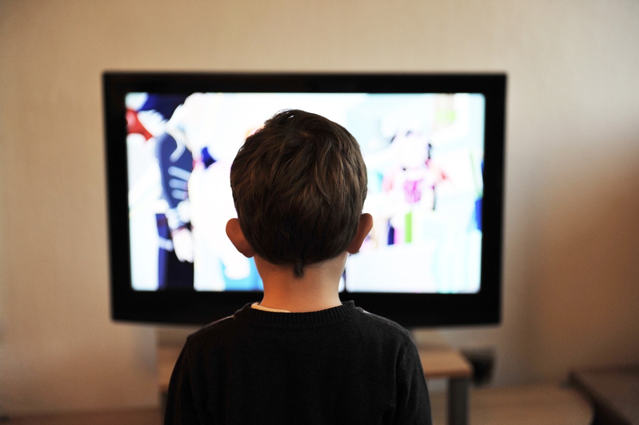 Child watching bright television screen