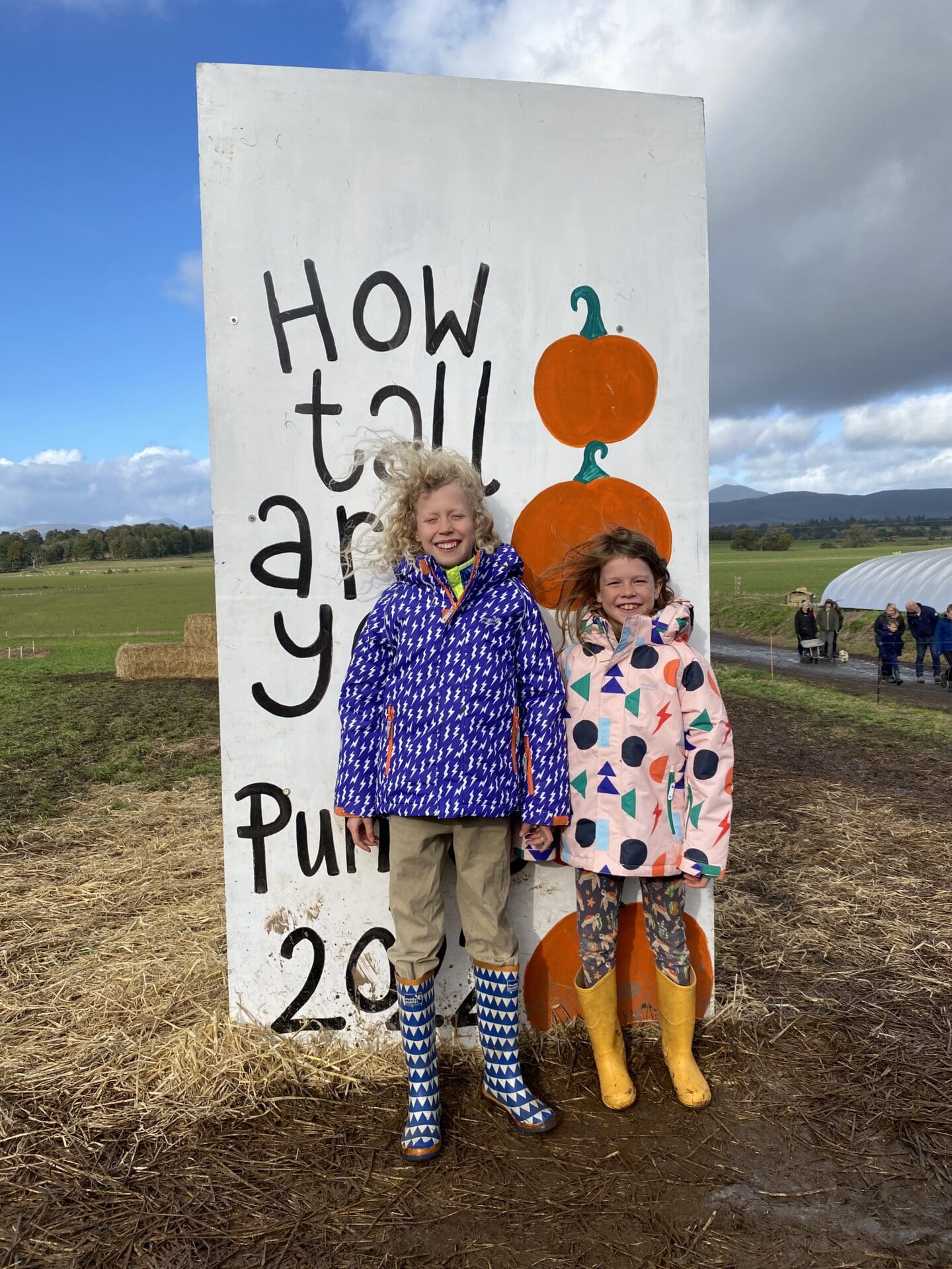 children by pumpkin sign