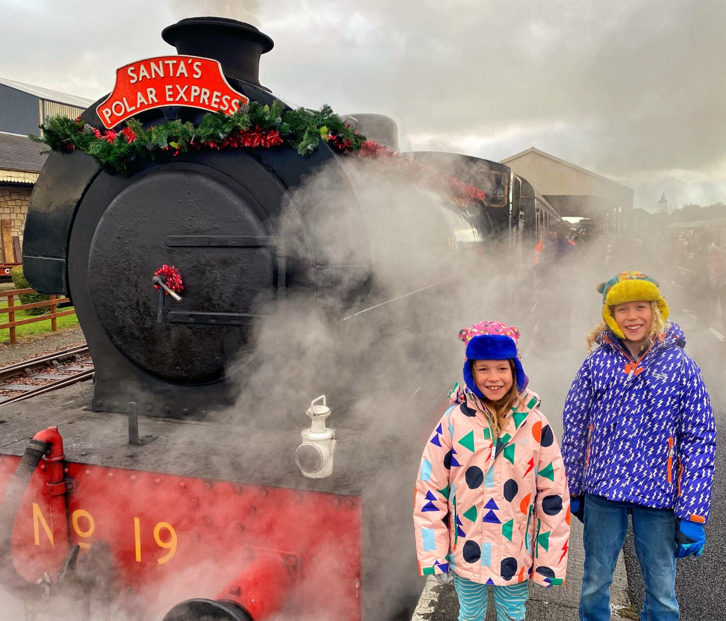 Children standing outside a steam train