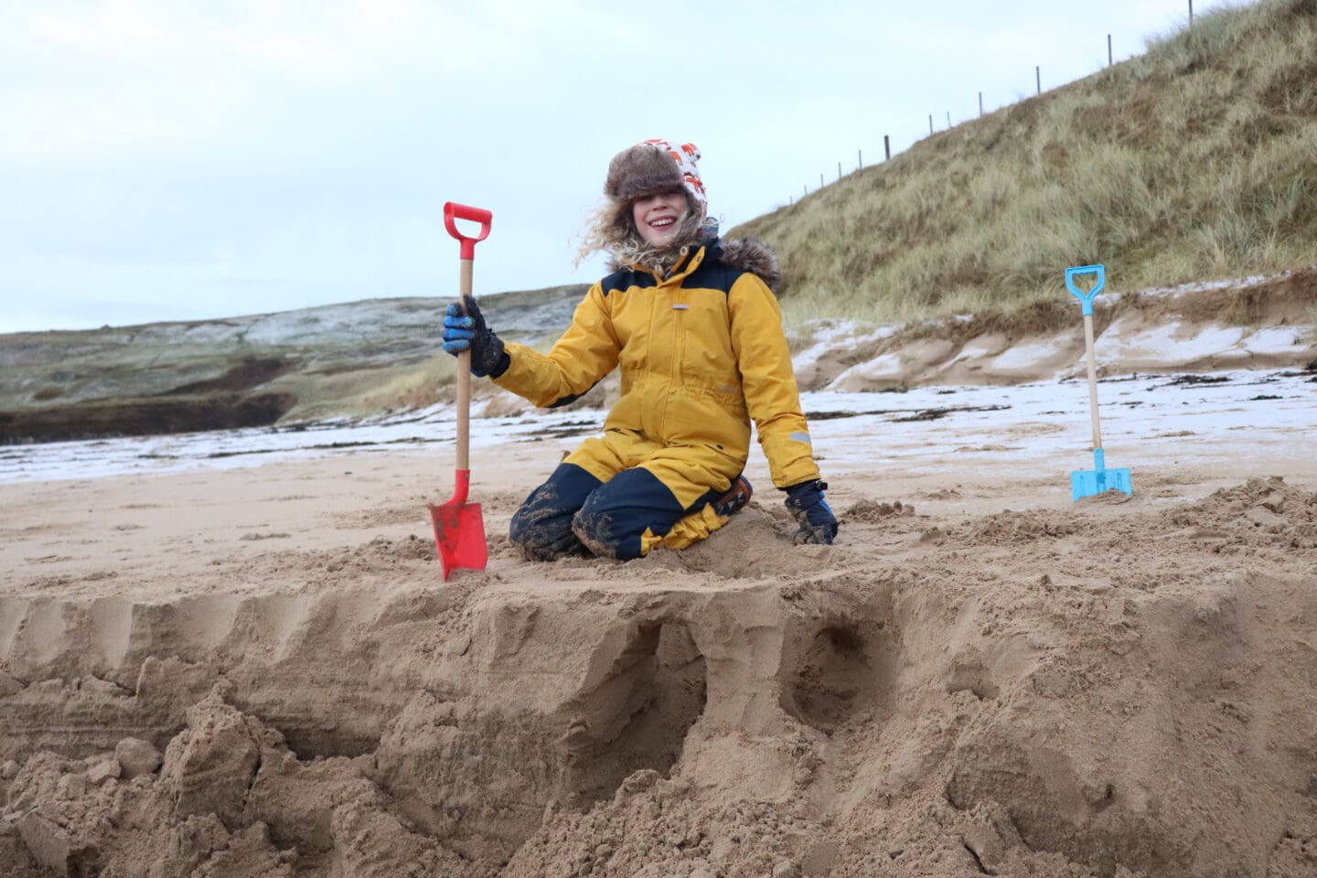 Child digging at beach with spade